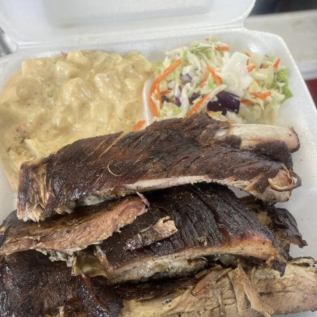 Ribs with potato salad and coleslaw in a takeout tray